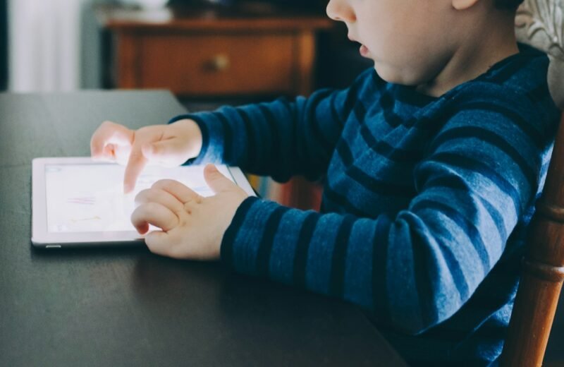 Boy sitting at a table using a tablet computer