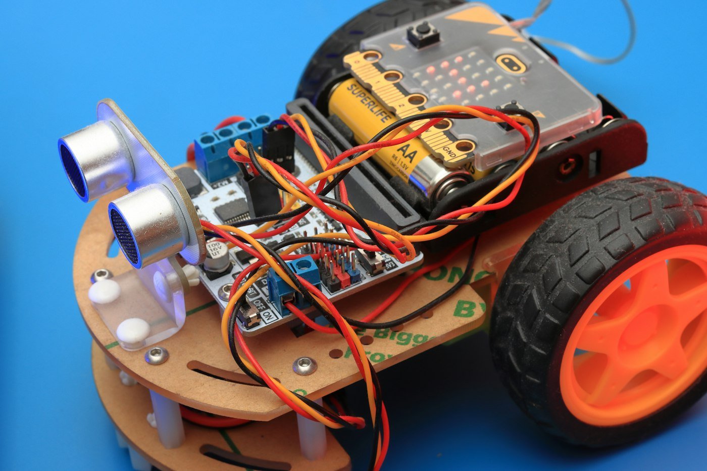 A small robot car with wheels and wires attached to it