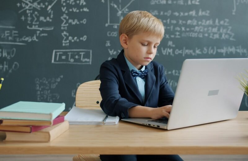 Boy using a laptop in a classroom to practice coding