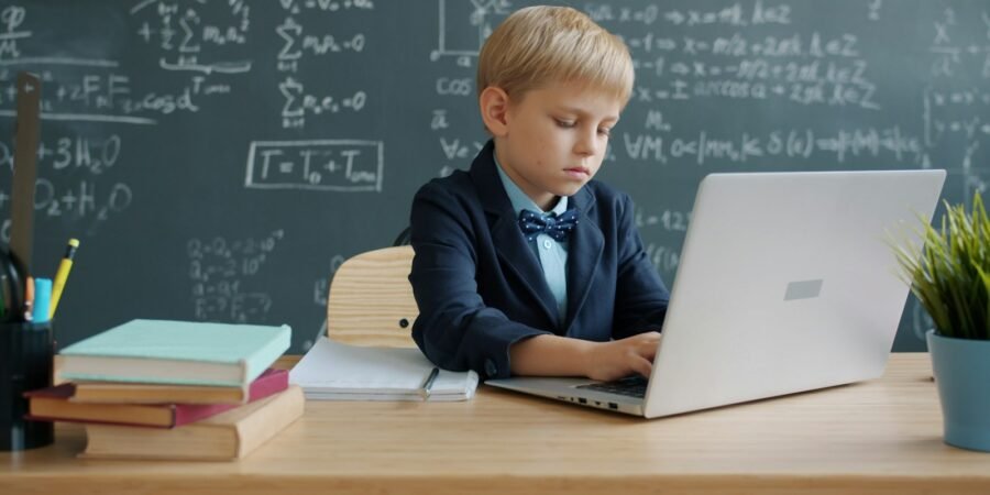 Boy using a laptop in a classroom to practice coding