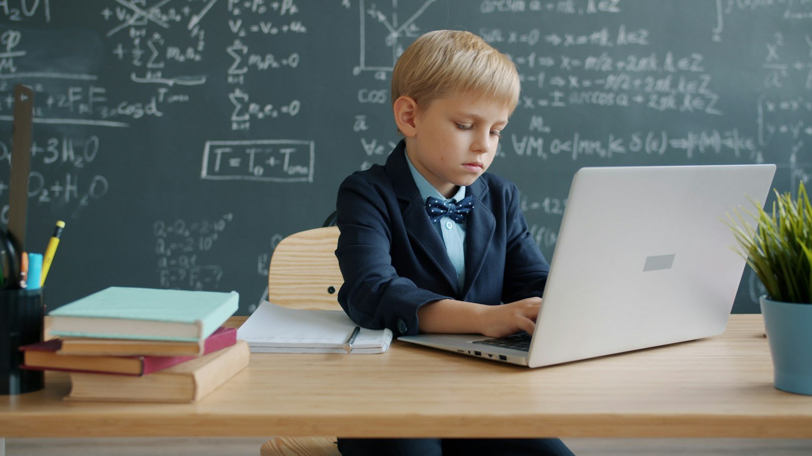 Boy using a laptop in a classroom to practice coding