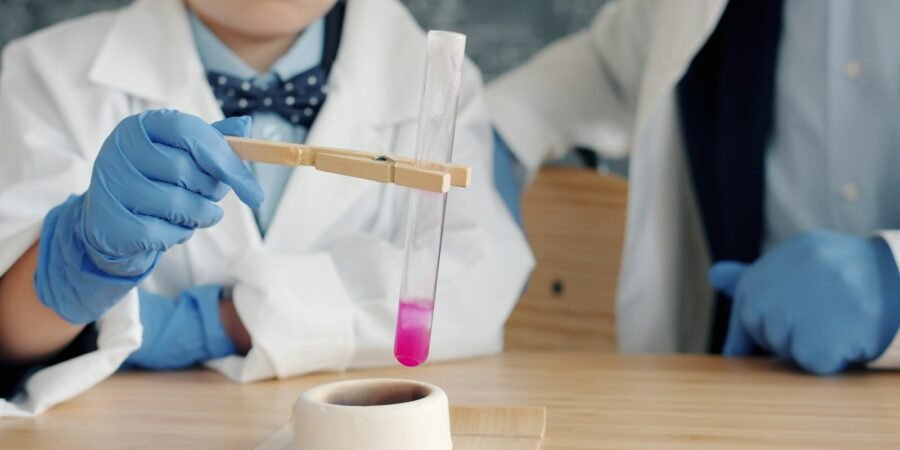 Children in lab coats conducting a science experiment as part of STEM education