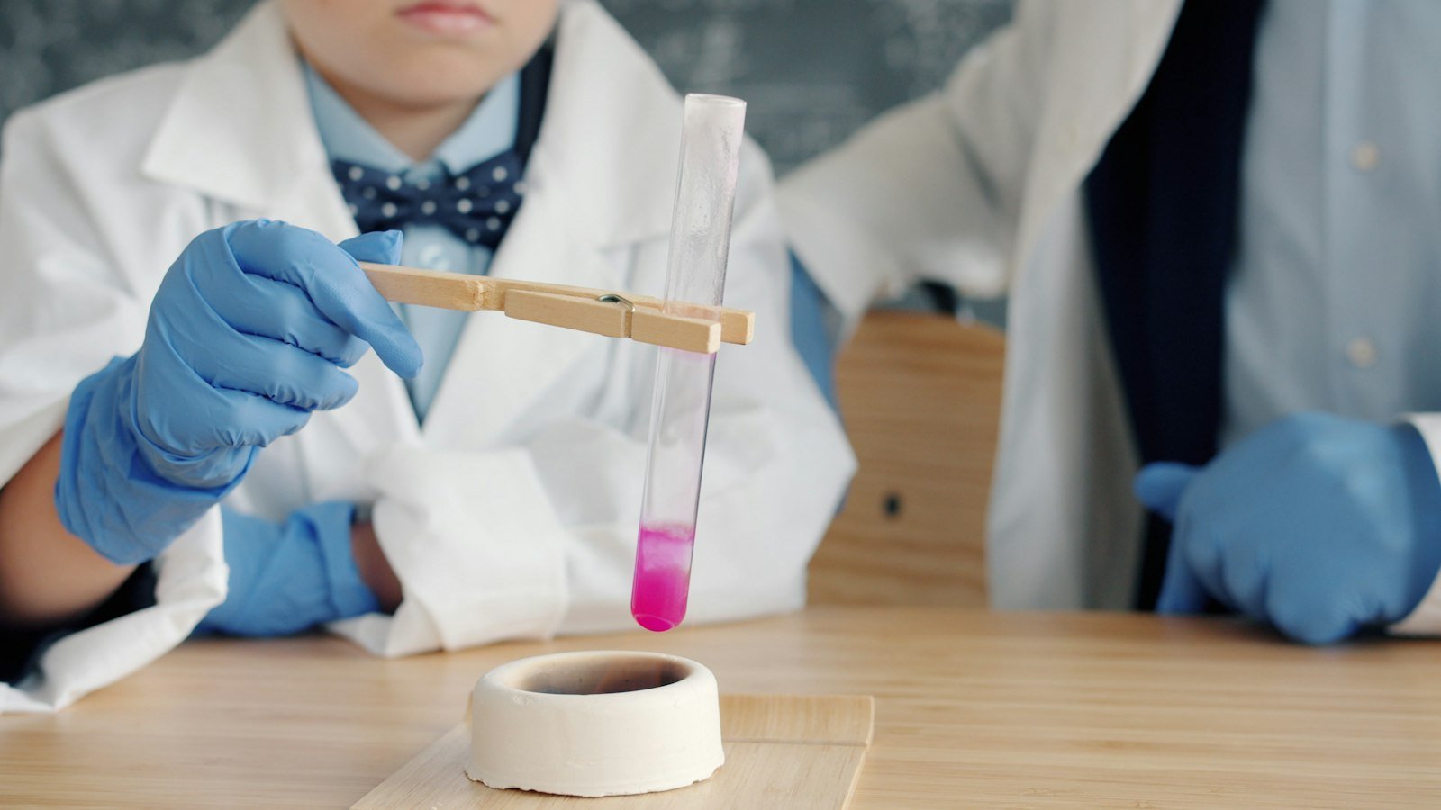 Children in lab coats conducting a science experiment as part of STEM education