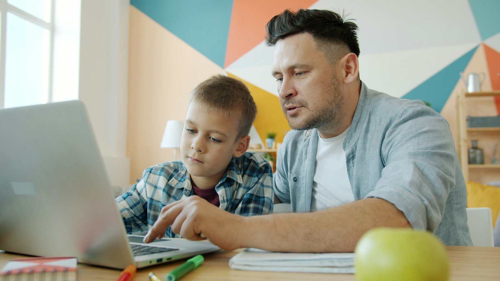 Father and son learning together on a laptop